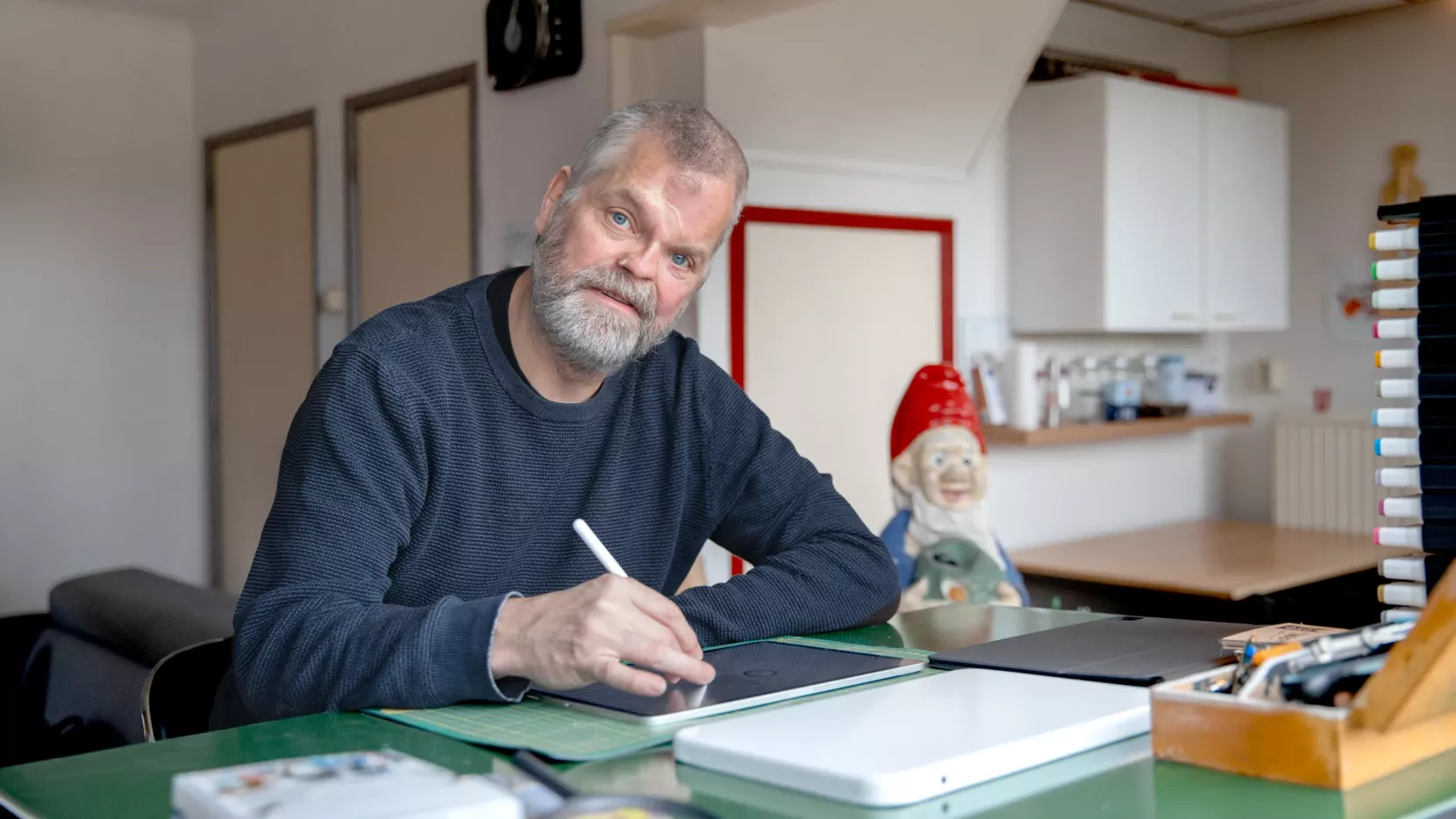 Portret Arjen Frijlink, grafisch vormgever. Hij ontwerpt op zijn tablet.