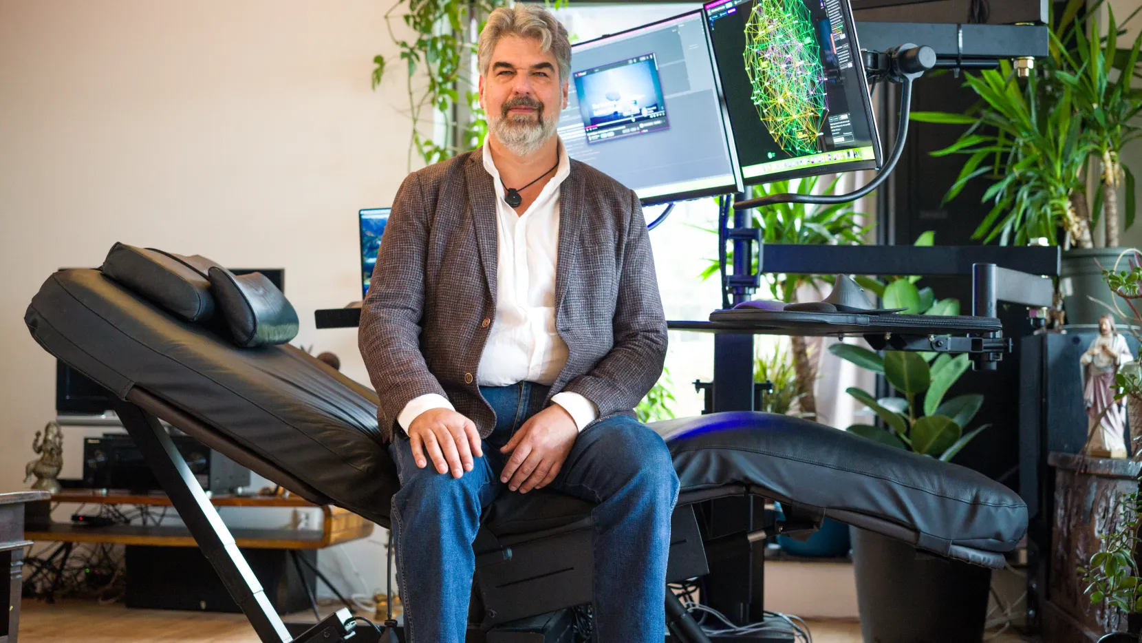 Portret van Bjorn. Hij zit op zijn speciale in hoogte verstelbare ligstoel. Aan de voorkant van de ligstoel zijn er 2 computerschermen verbonden om te kunnen werken. 