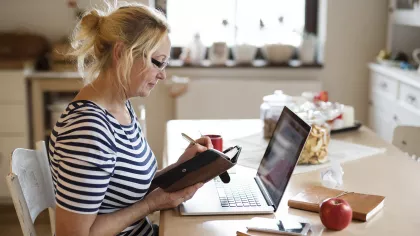 Foto van een vrouw die op haar telefoon kijkt of ze haar WIA-uitkering heeft ontvangen.