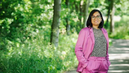 Madhu Mathura staat in een roze pak op een plek in de natuur