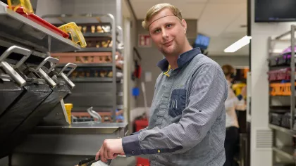 Foto van Nicky die een hamburger bakt tijdens het werken bij McDonald's