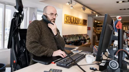 Foto van Peter van Burk, aan het werk met een van de werkvoorzieningen: een sta-op rolstoel.