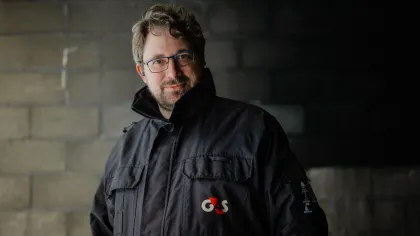 Portret van Fransz. Hij heeft een zware jas aan en kijkt glimlachend de camera in.