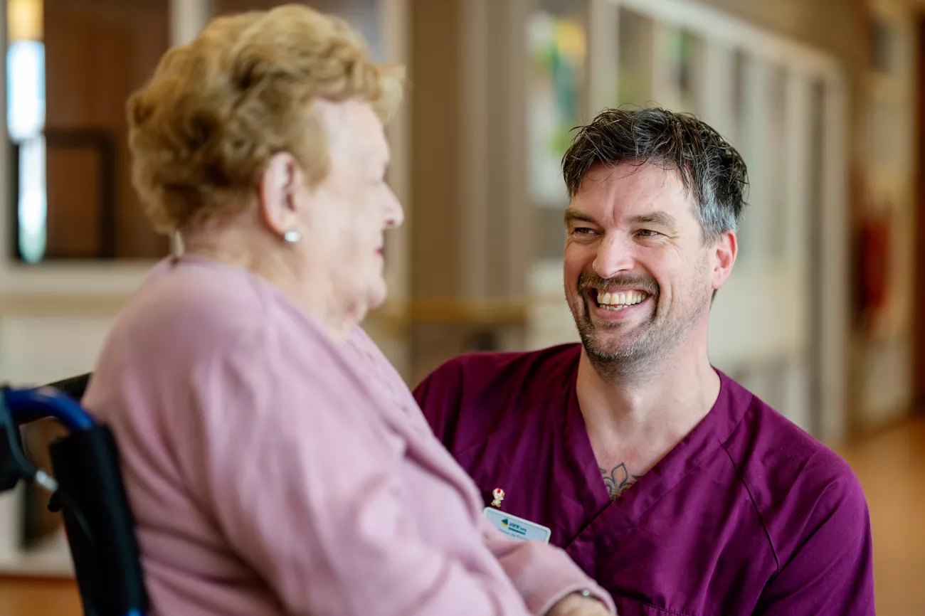 Foto van Menno op zijn werk met een bewoner