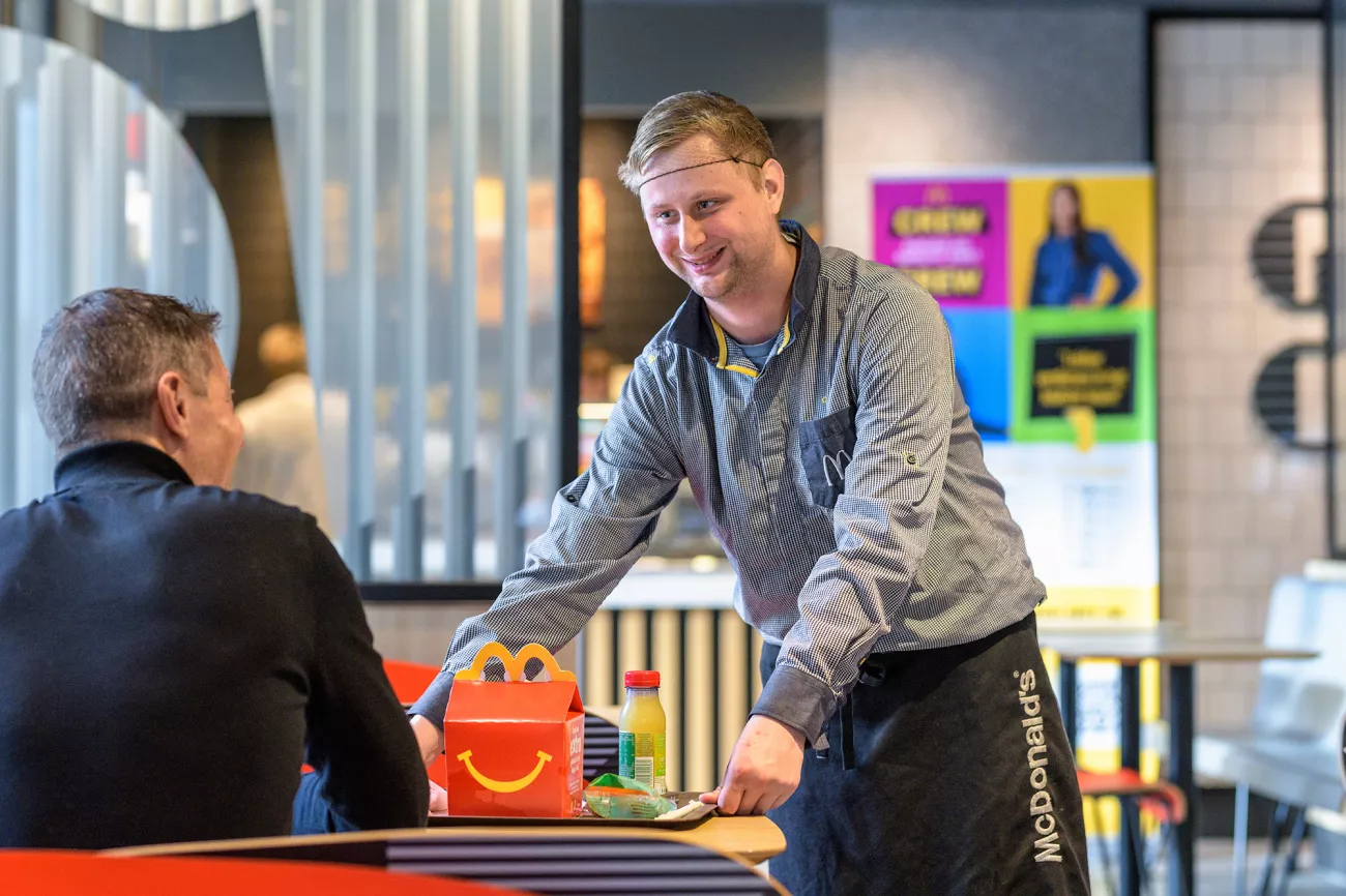 Foto van Nicky die een Happy Meal aan een klant geeft