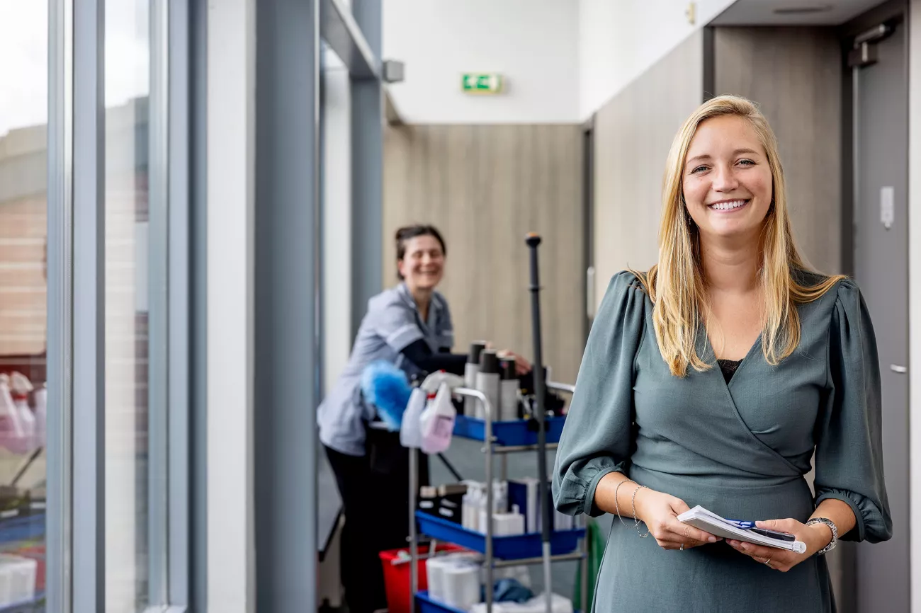 Foto van Simone, zij maakt solliciteren laagdrempelig met open hiring. Je ziet op de achtergrond medewerker Violeta aan het werk en lachen