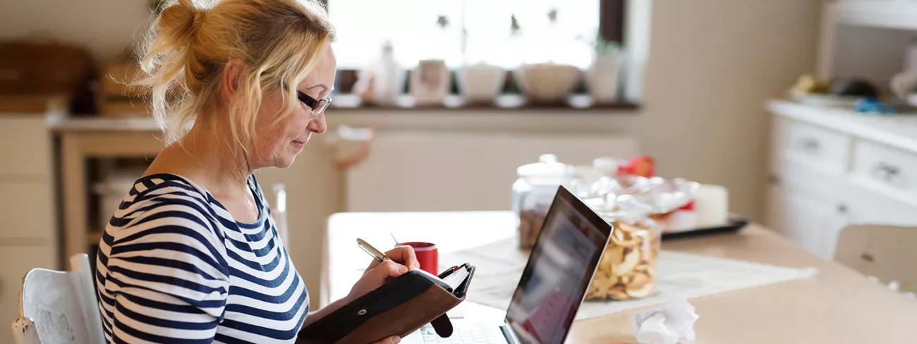 Foto van een vrouw die op haar telefoon kijkt of ze haar WIA-uitkering heeft ontvangen.