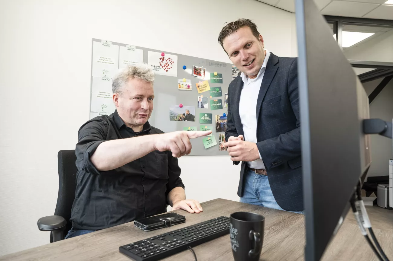 Willem en zijn werkgever Jack Stuifbergen samen op de foto: Willem zit aan en bureau