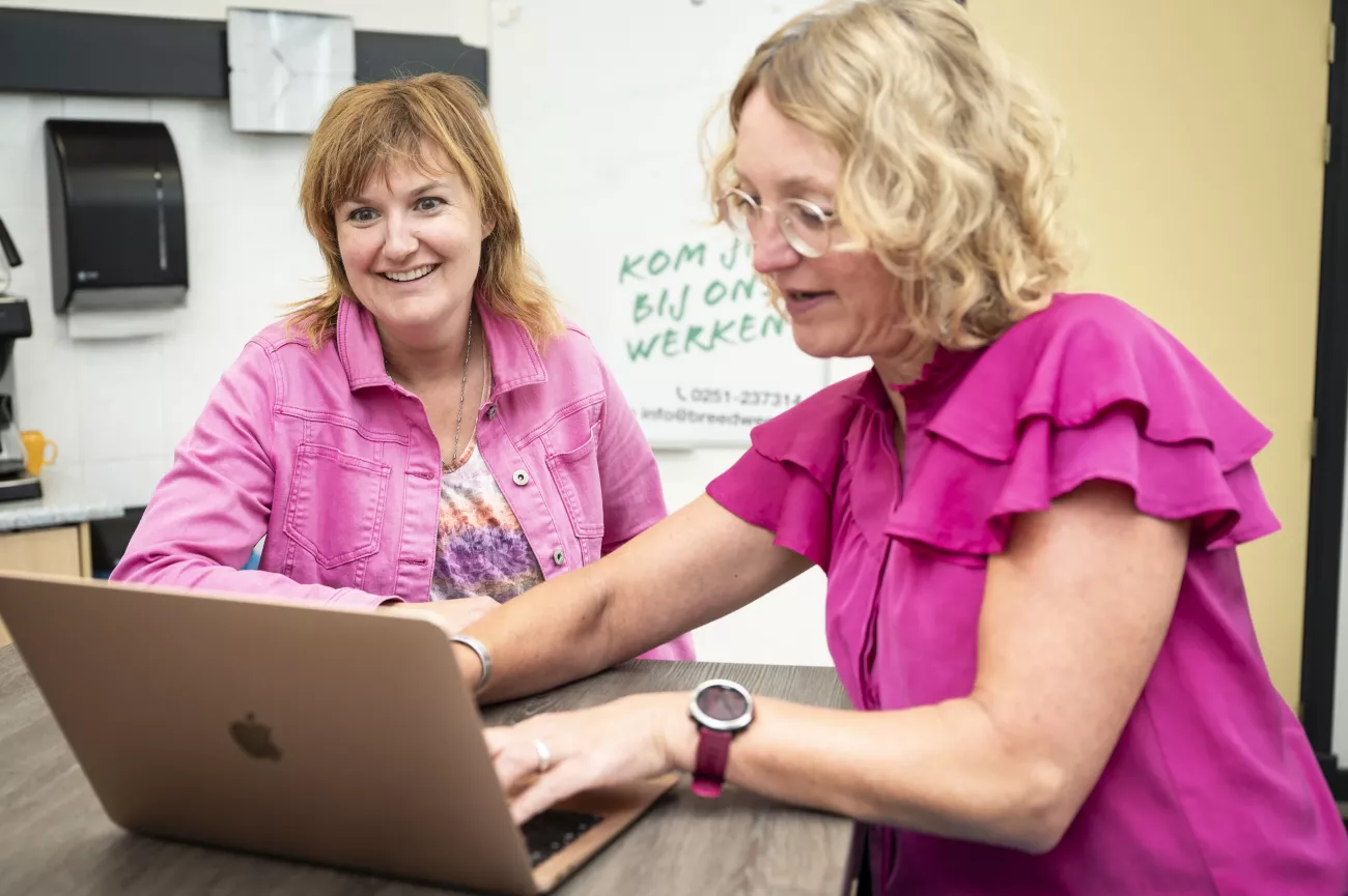 Roselien zit naast een collega en ze kijken naar een laptopscherm