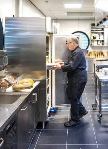 Foto van Jaap, aan het werk in de keuken, via omscholing op latere leeftijd