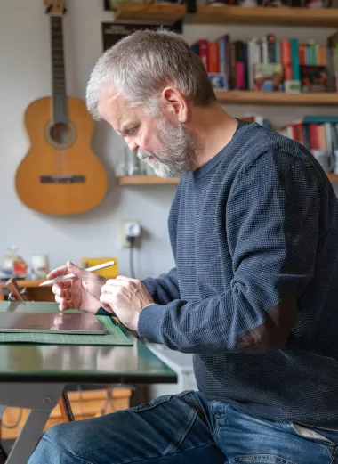 Portret Arjen Frijlink, hij is aan het werk als grafiasch vormgever