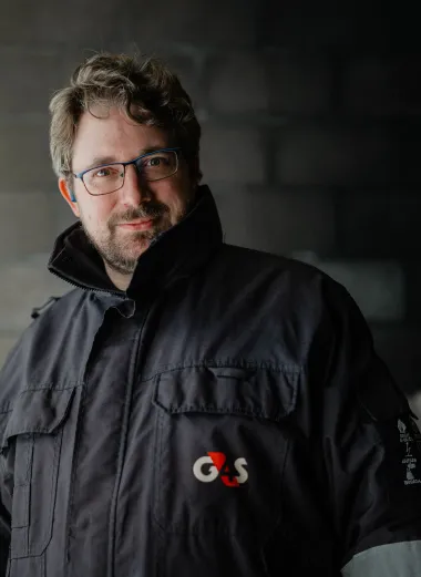 Portret van Fransz. Hij heeft een zware jas aan en kijkt glimlachend de camera in.