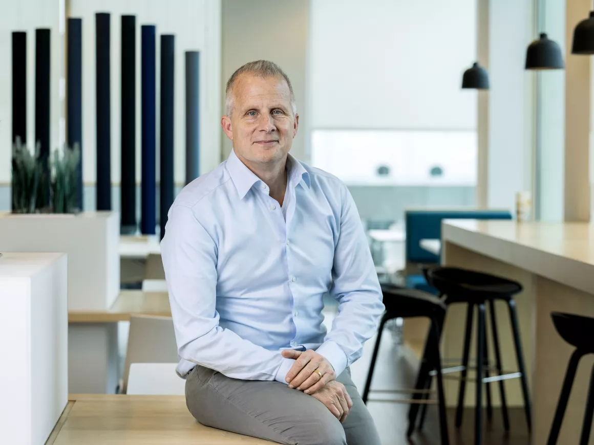 Michael Boud, recruitmentspecialist, zit op een tafel in een kantooromgeving